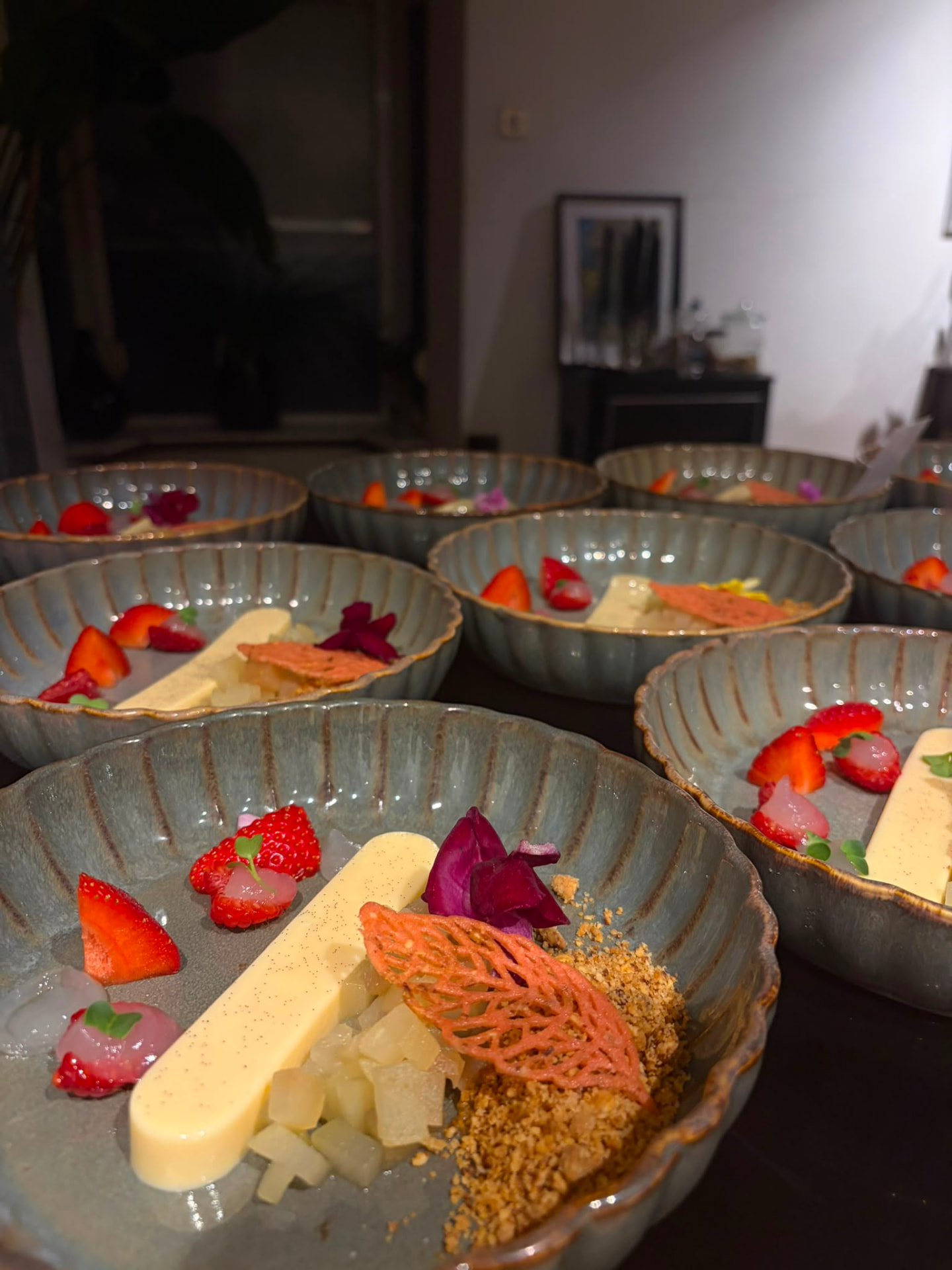 Uitgebreid dessert met vanille, aardbei en crumble in keramische schalen